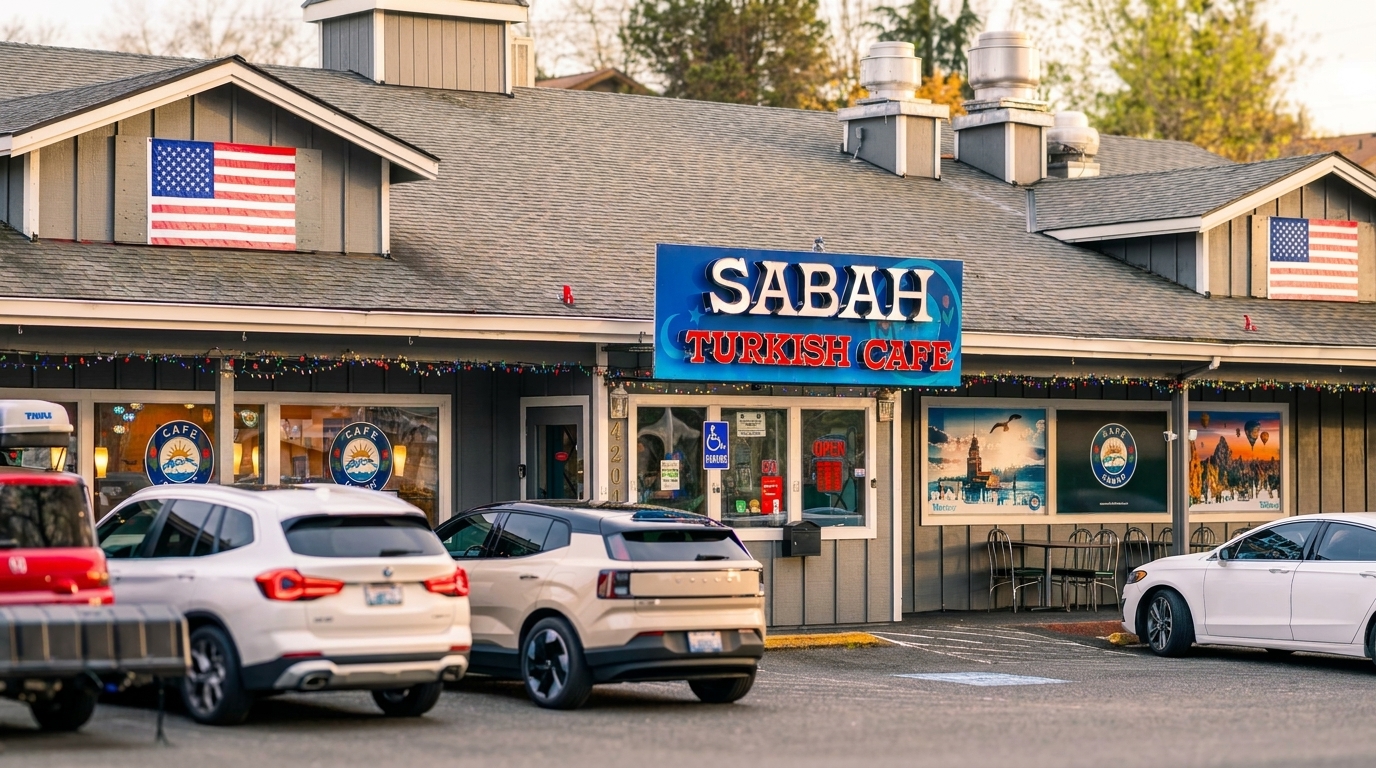 Exterior of Sabah Turkish Cafe with cars parked in front, American flags, and festive lights.
