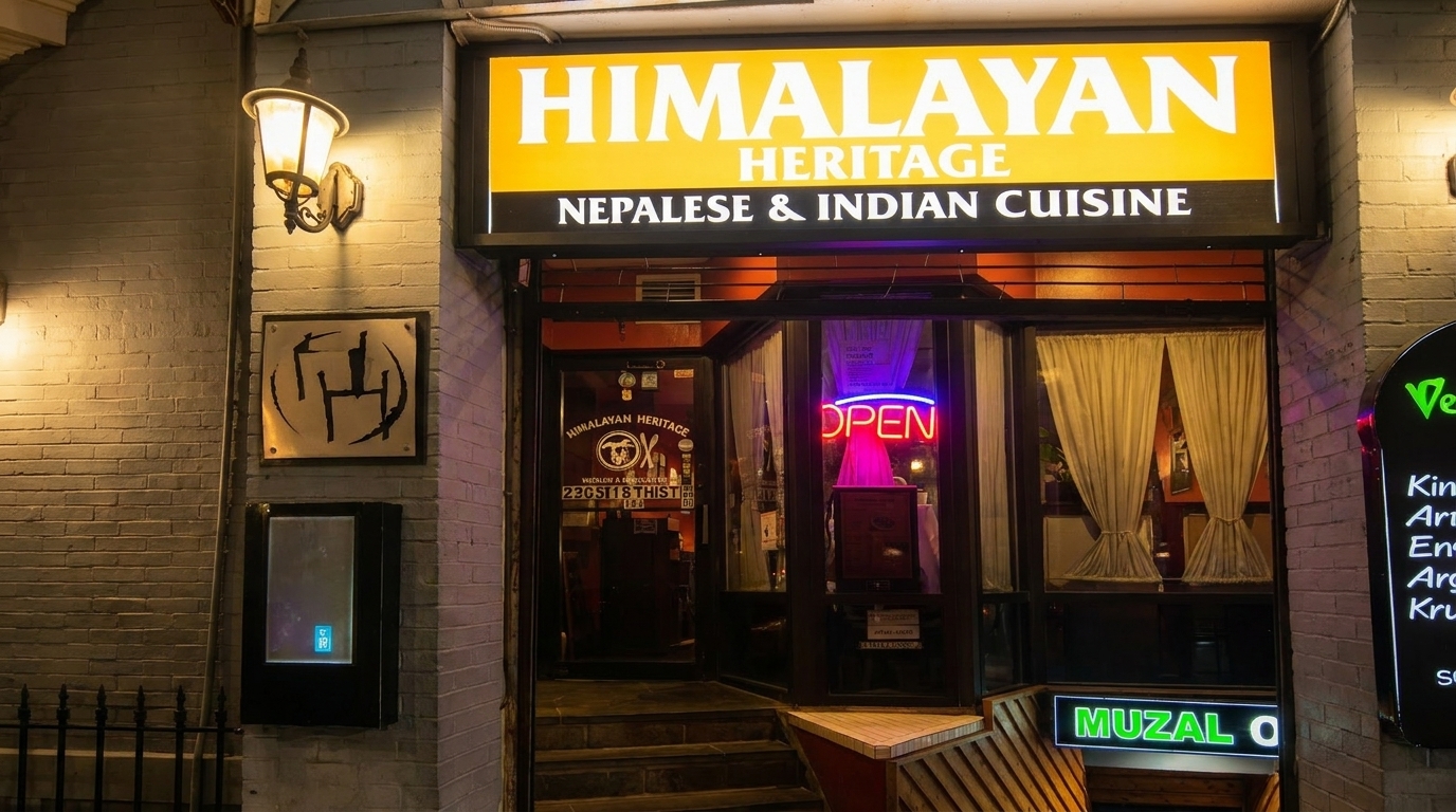 Exterior of Himalayan Heritage restaurant at night, with a bright sign and an "OPEN" neon sign.