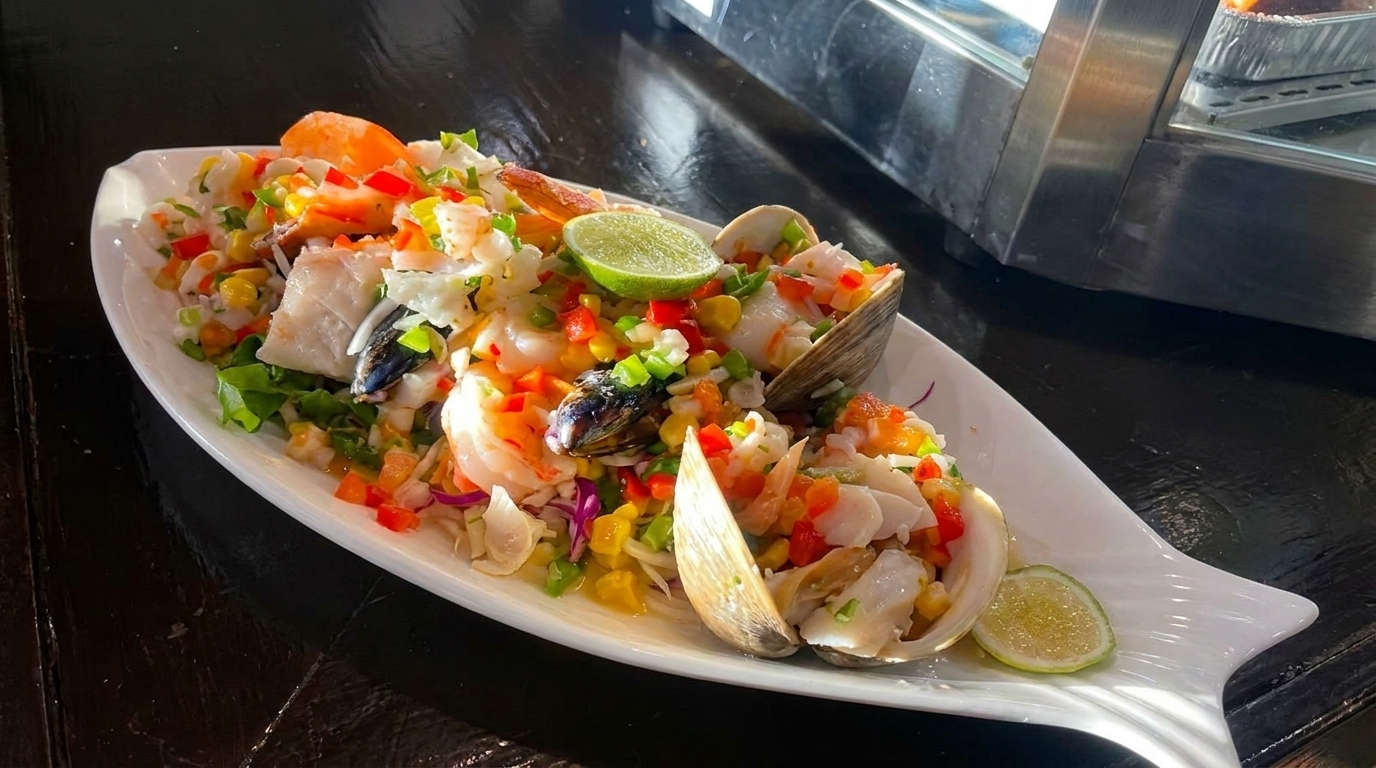 Seafood ceviche with shrimp, clams, mussels, fish, corn, and peppers, garnished with lime.
