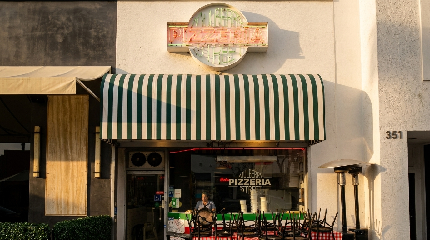 Mulberry Pizzeria Street storefront with a green and white striped awning and neon sign.