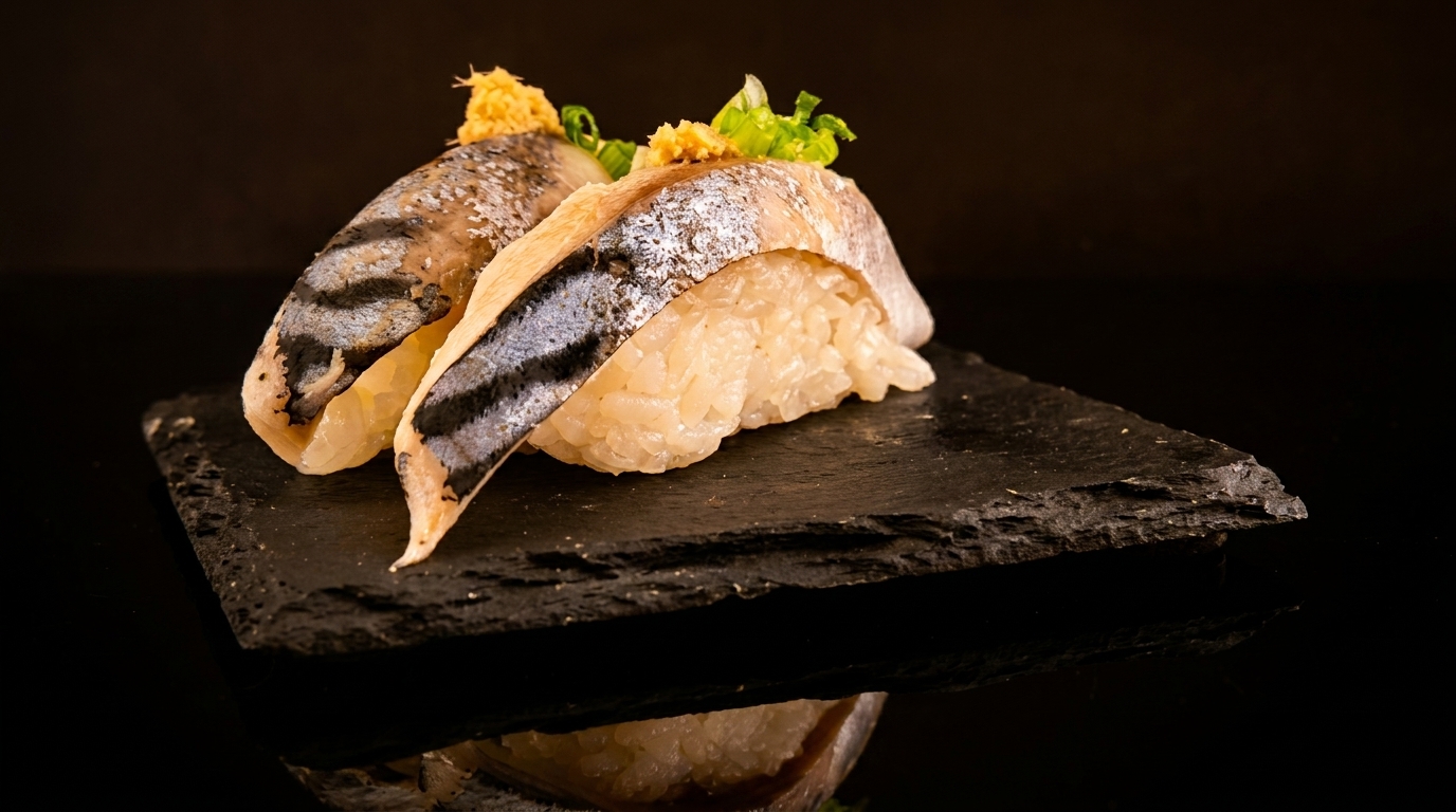 Two pieces of nigiri sushi with fish, rice, and green garnish on a dark slate plate.