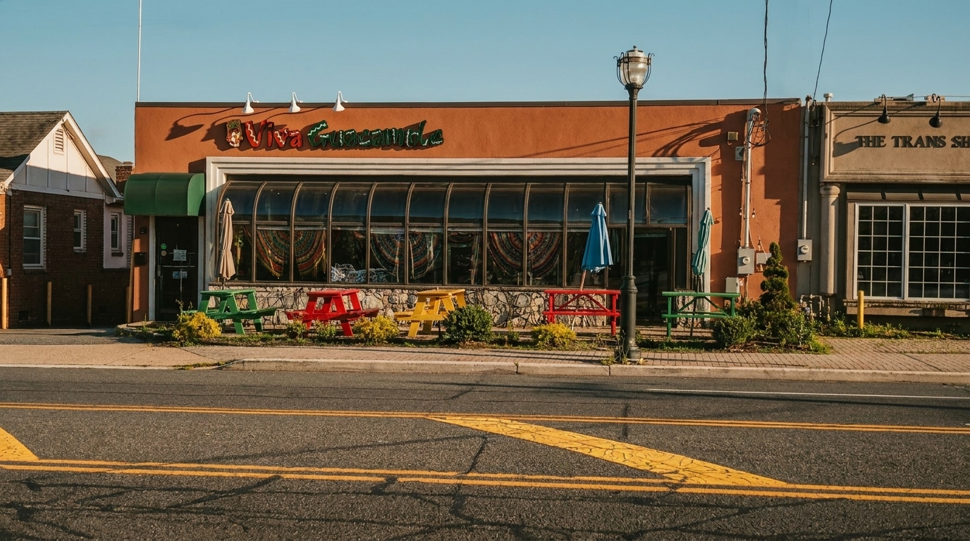 Viva Guacamole restaurant exterior with colorful picnic tables and a large curved window facade.