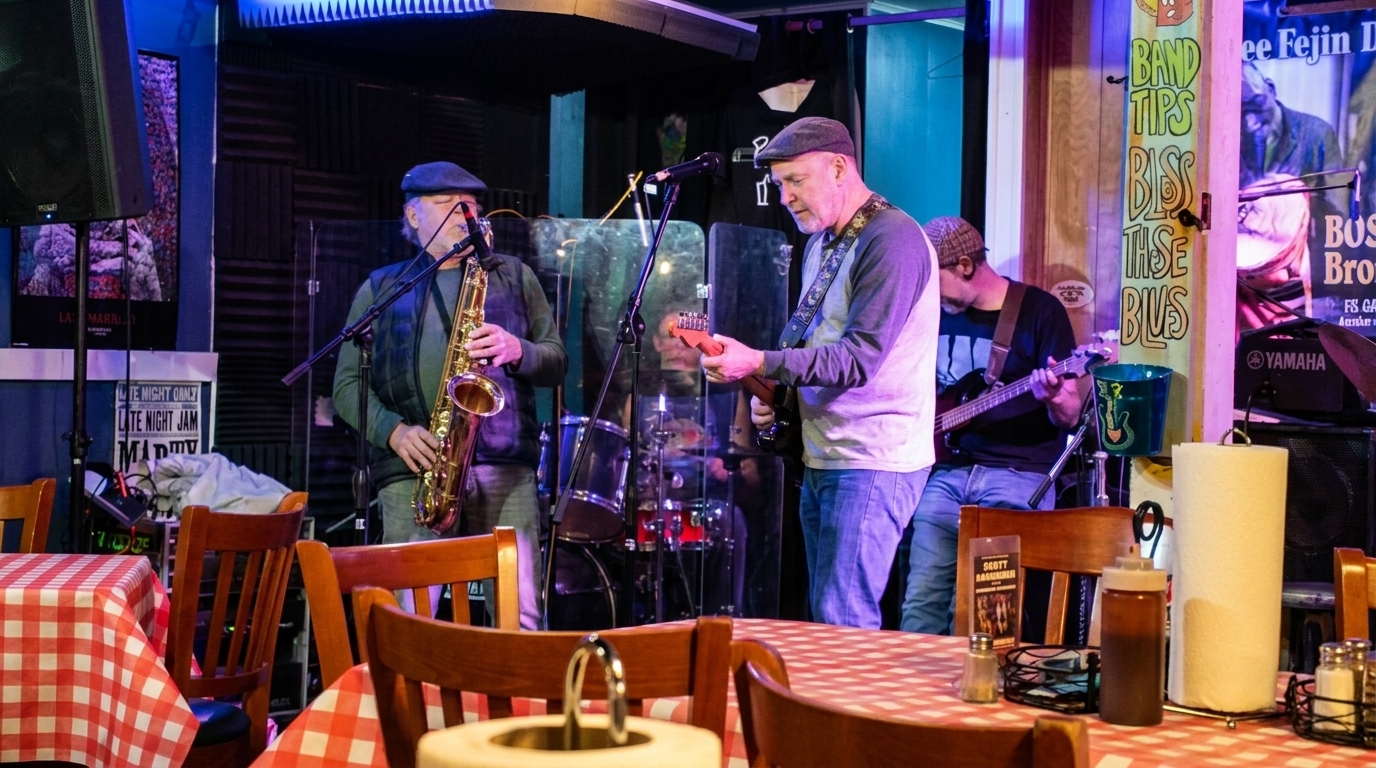 A band performs live music on a stage with red and white checkered tables in the foreground.