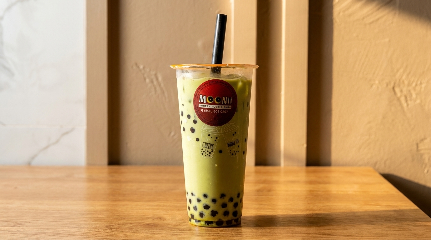 A Moonii Korean Food & Boba matcha bubble tea with tapioca pearls on a wooden table.