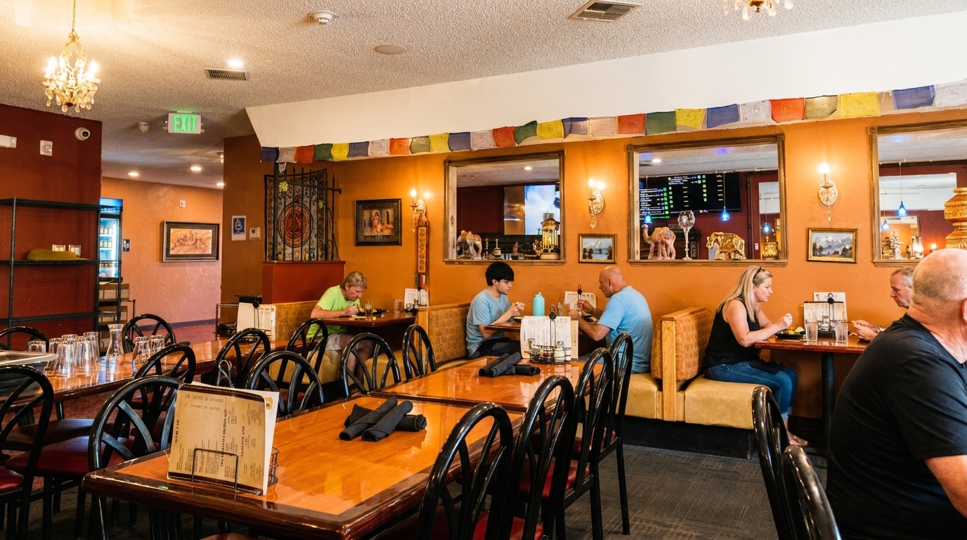 Restaurant interior with patrons dining at tables and booths, decorated with colorful prayer flags.