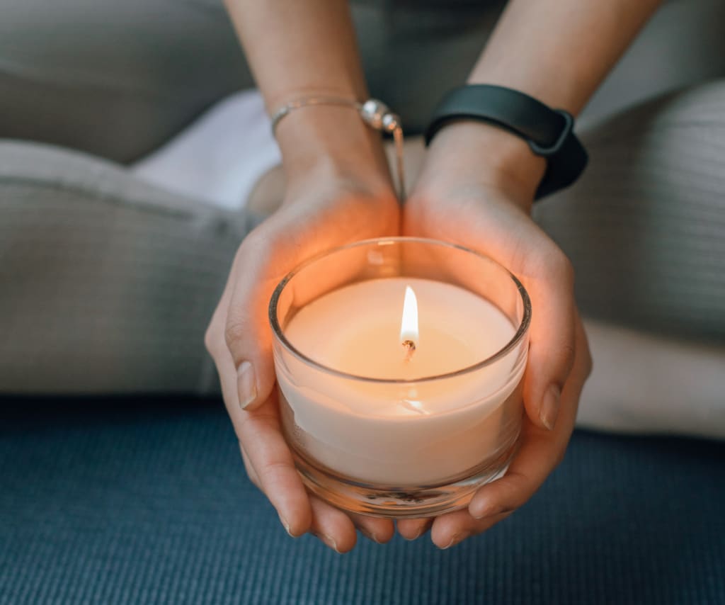 Hands holding a lit candle