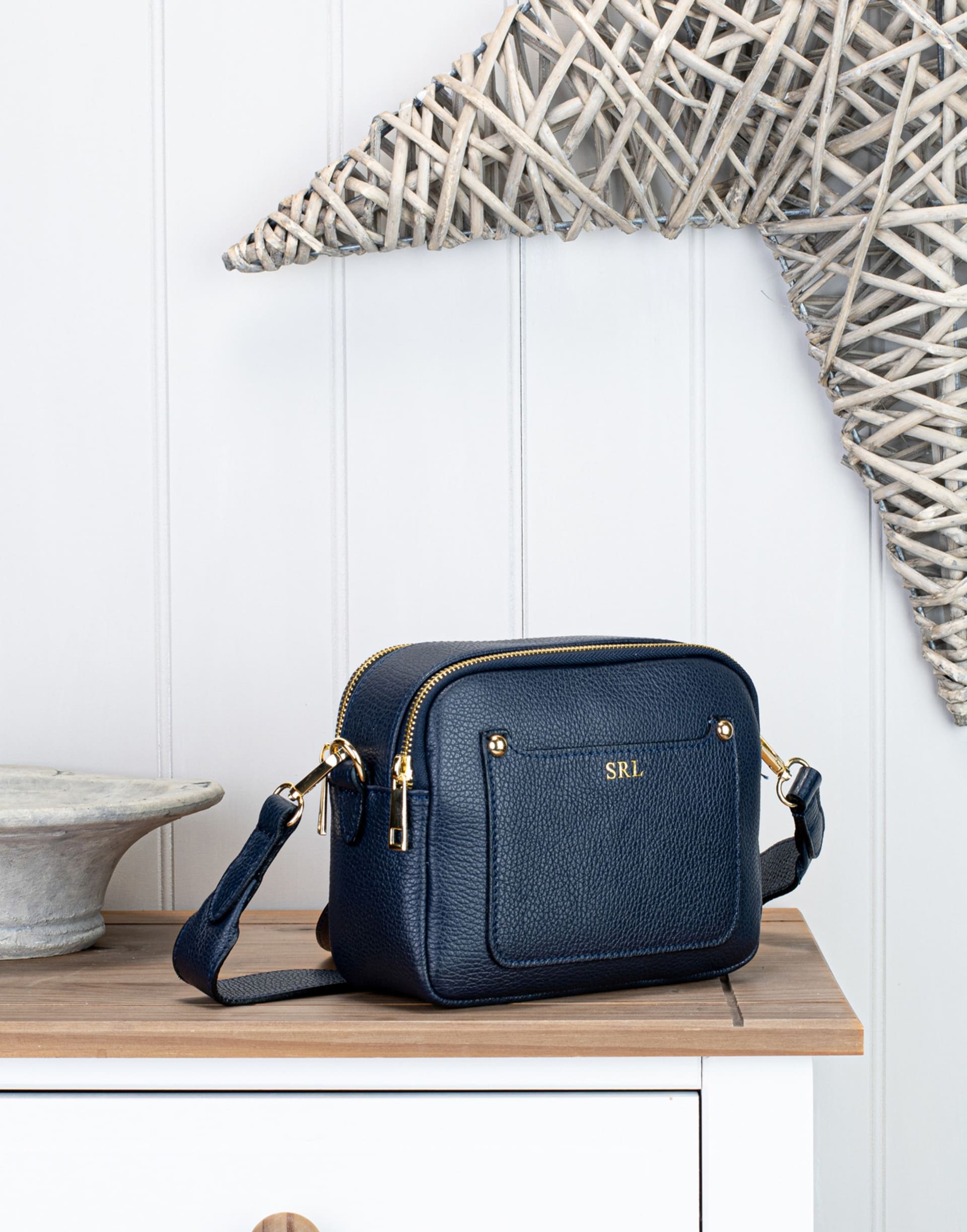 Navy leather crossbody bag lifestyle with coastal decor - bag lifestyle photography UK