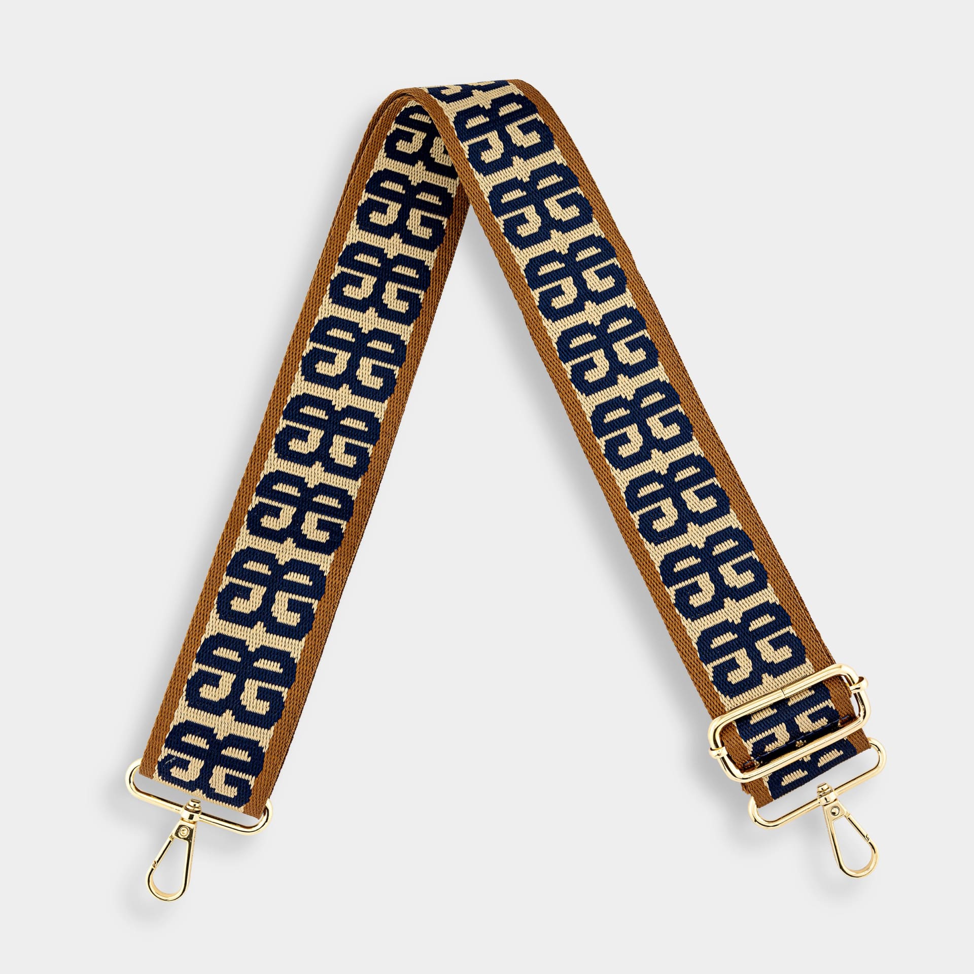 Patterned bag strap with gold hardware packshot on white - accessory product photography UK