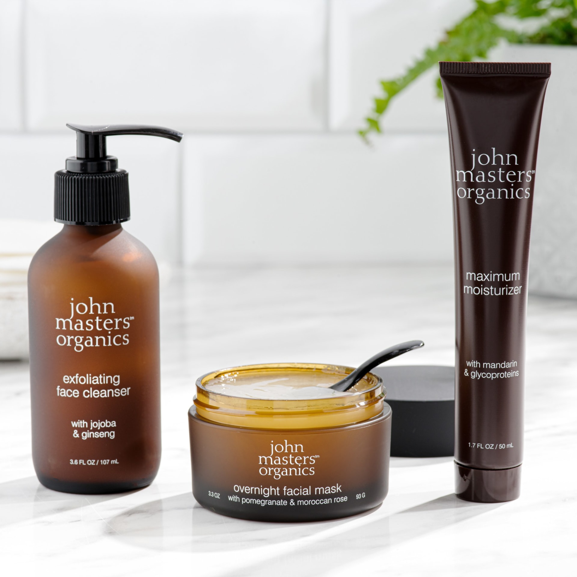 Organic skincare trio lifestyle arrangement on marble surface - beauty product photography UK
