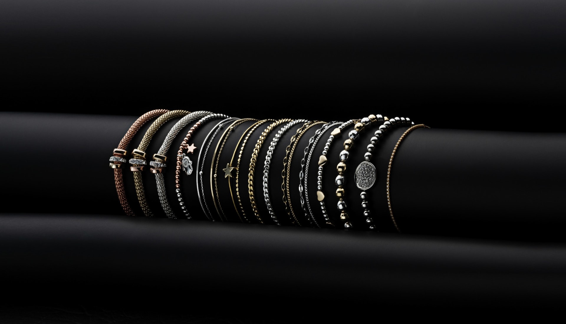 Stacked gold and silver bracelets on display - creative jewellery studio photography UK