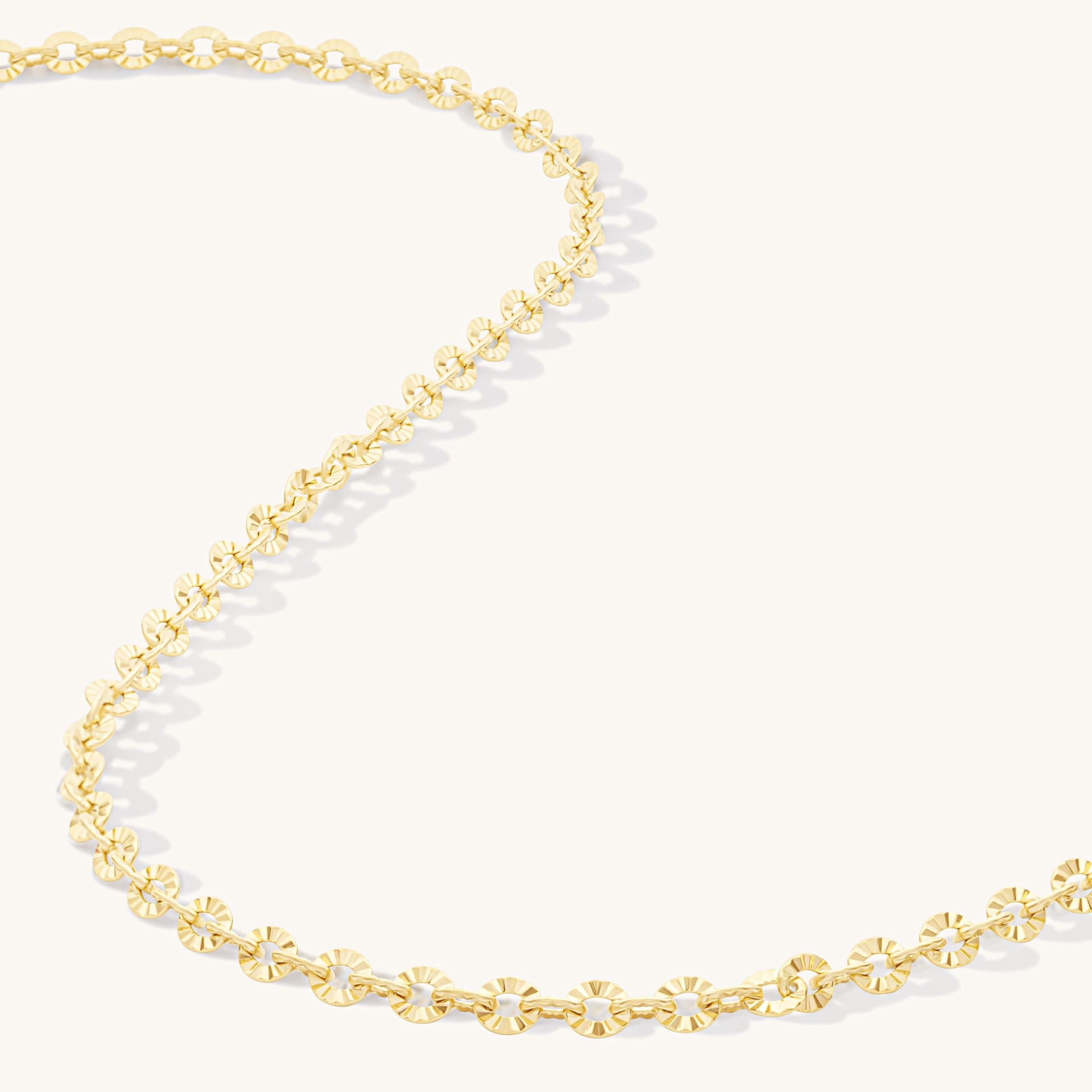 Gold chain necklace textured sunburst links close-up - jewellery craftsmanship photography UK