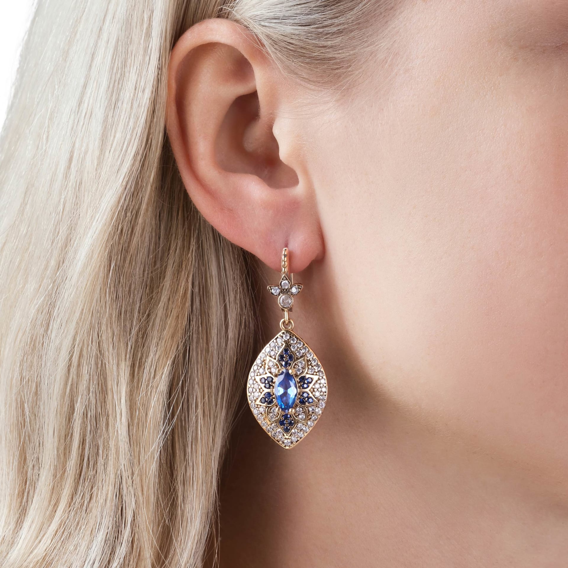 Gold sapphire drop earring close-up on model - premium jewellery lifestyle photography UK