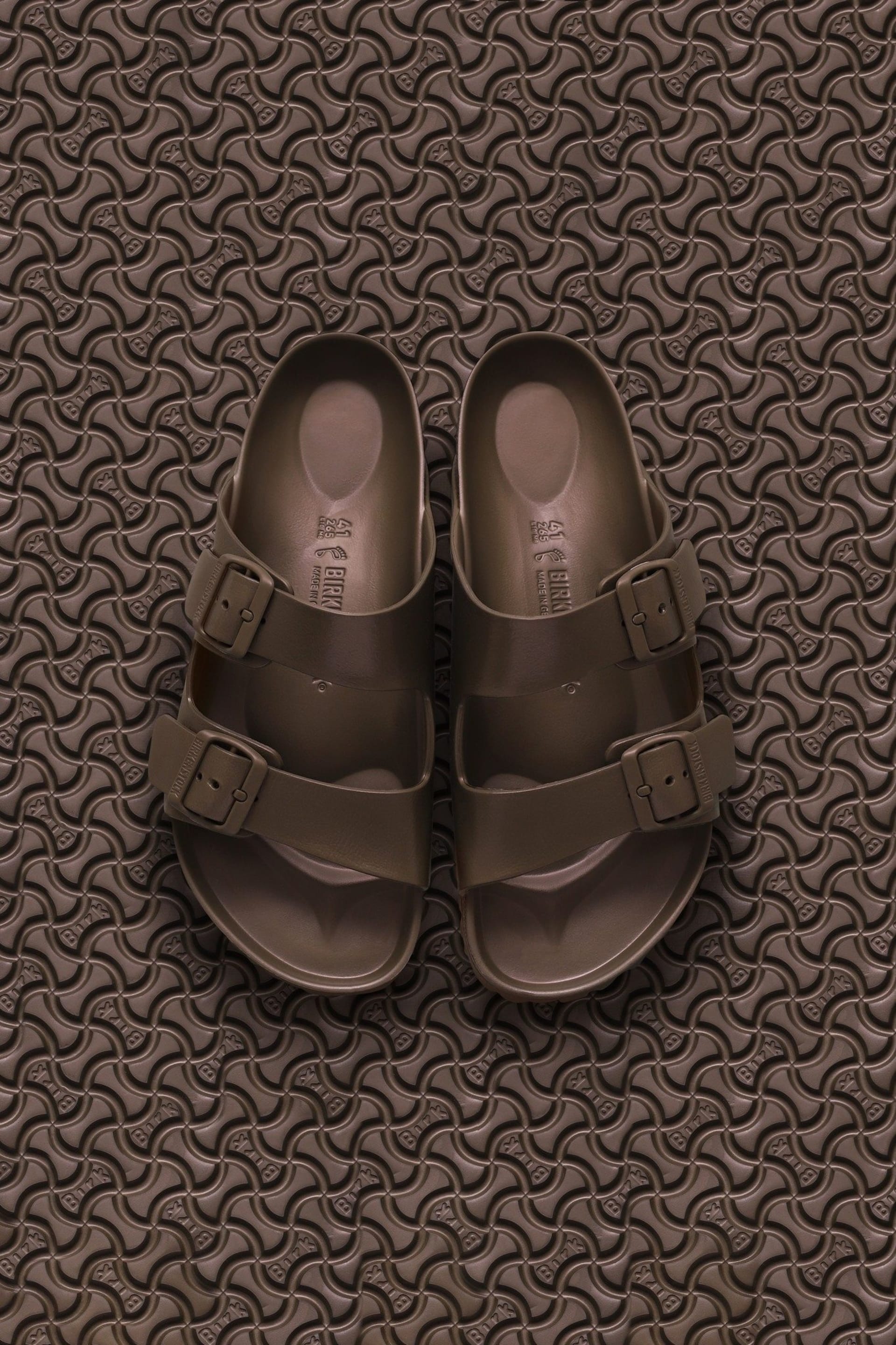Brown Birkenstock sandals EVA flat lay on textured surface - footwear product photography UK