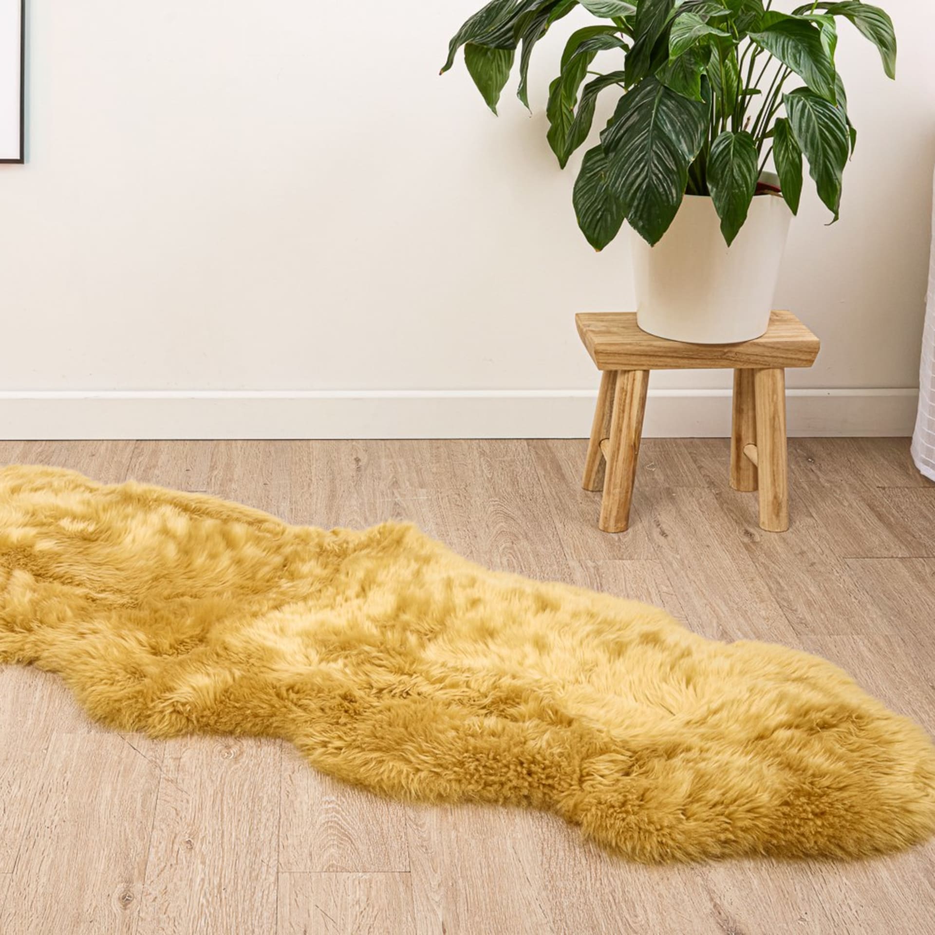 Mustard sheepskin rug lifestyle on wooden floor - material product photography UK