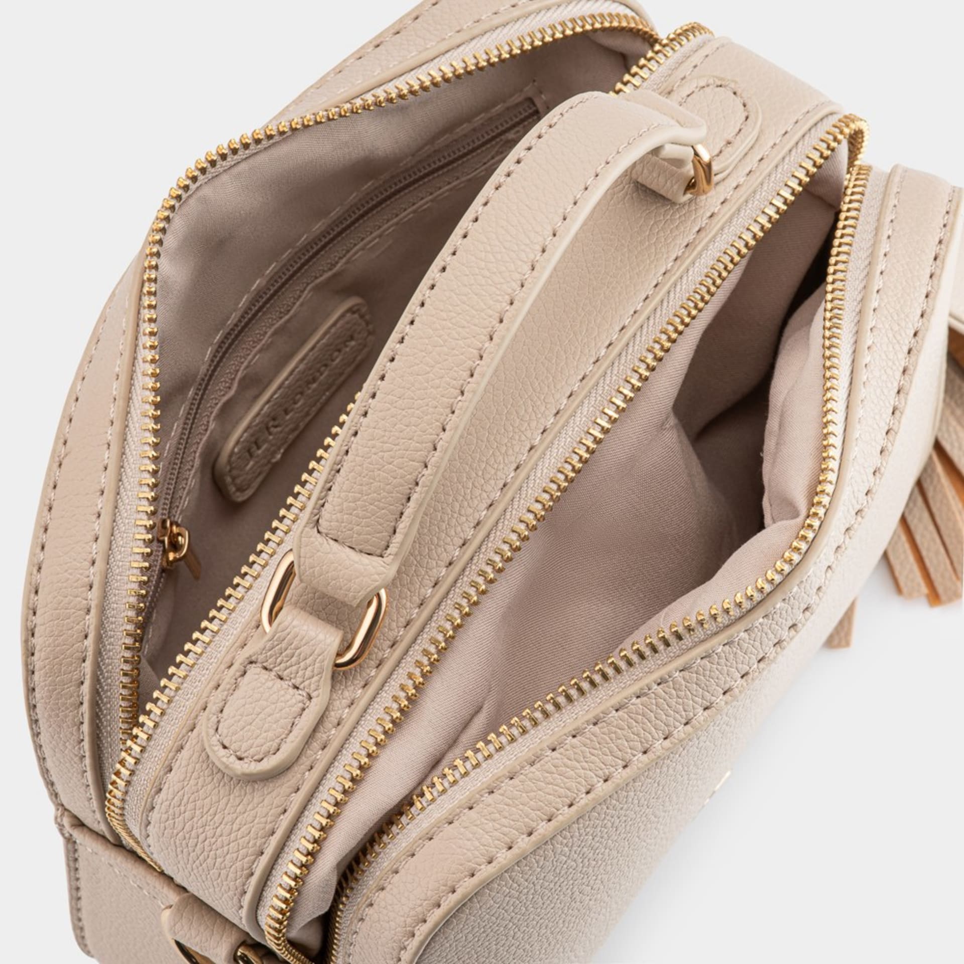 Beige crossbody bag interior detail with gold hardware - product photography UK