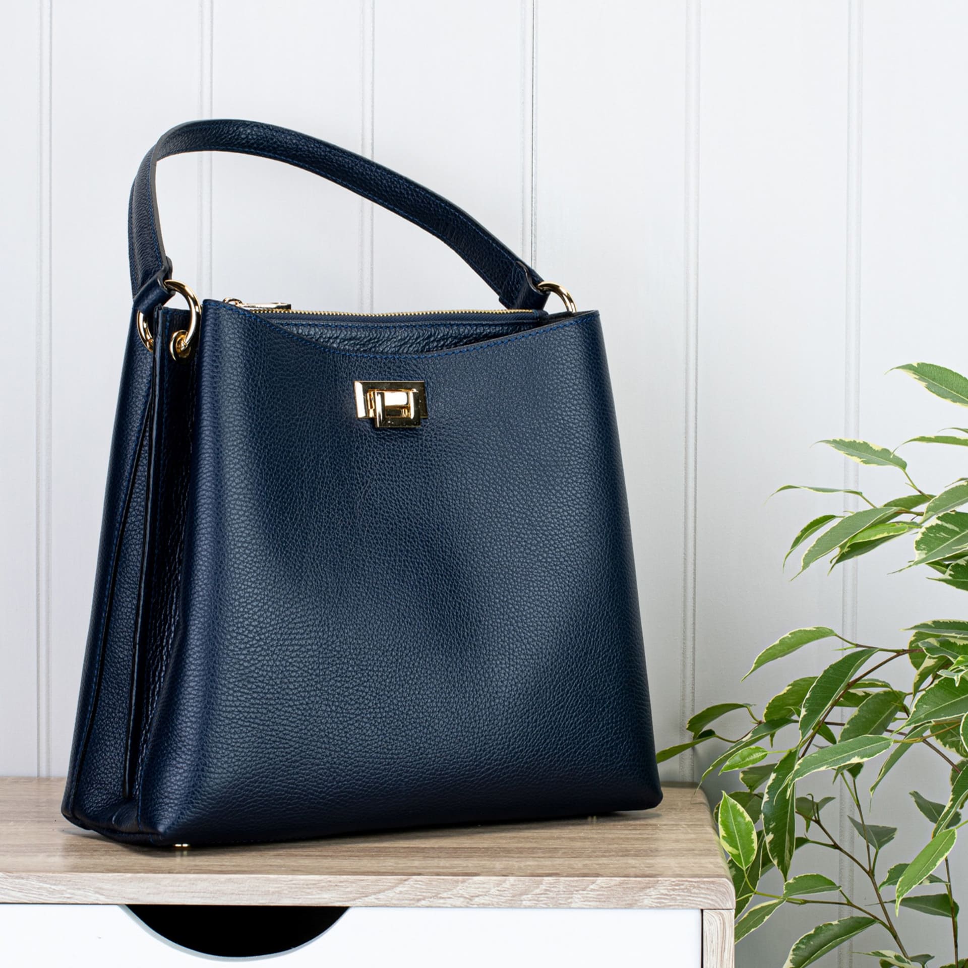 Navy leather handbag lifestyle with gold hardware - product photography UK
