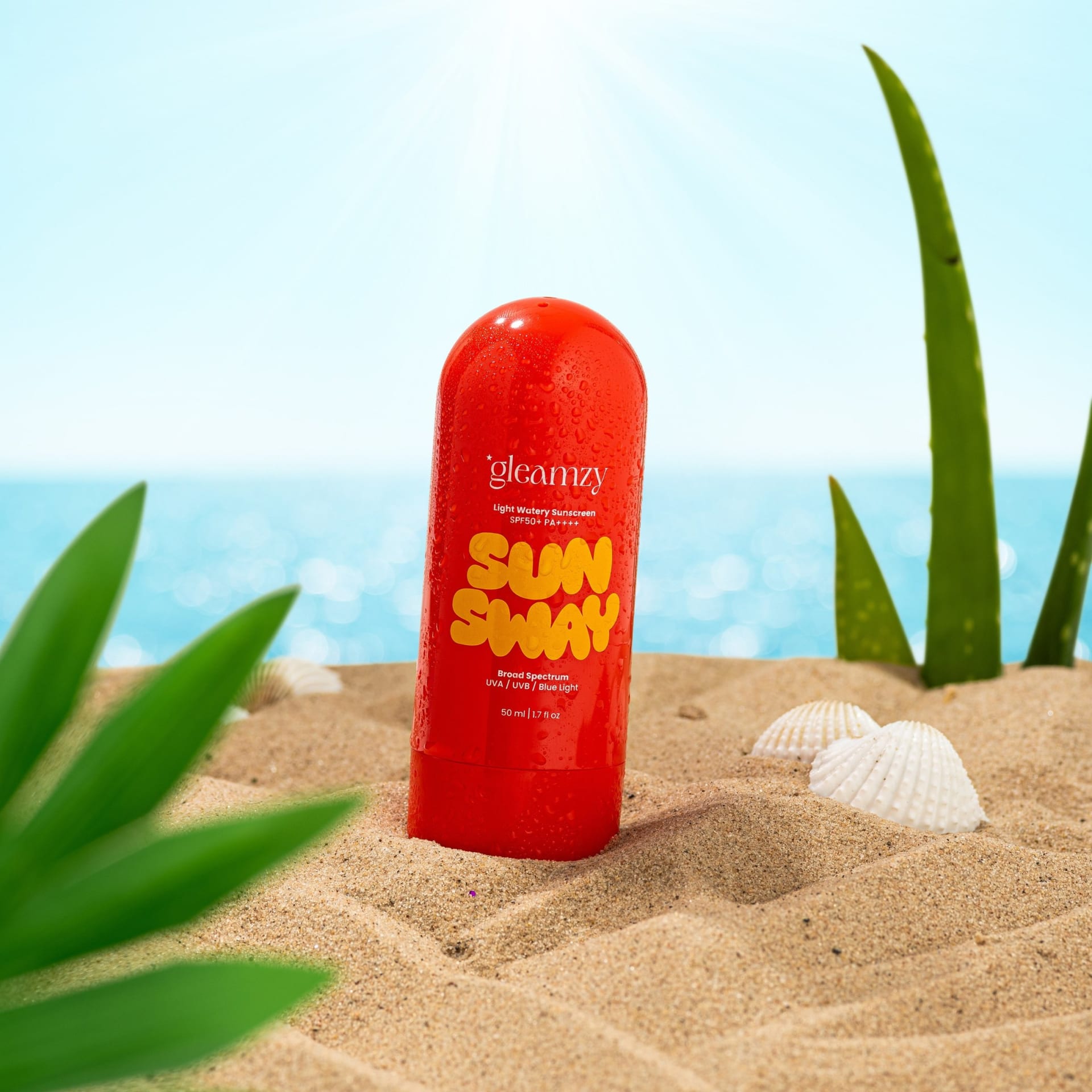 Red sunscreen bottle on beach sand summer lifestyle photography - beauty styling UK