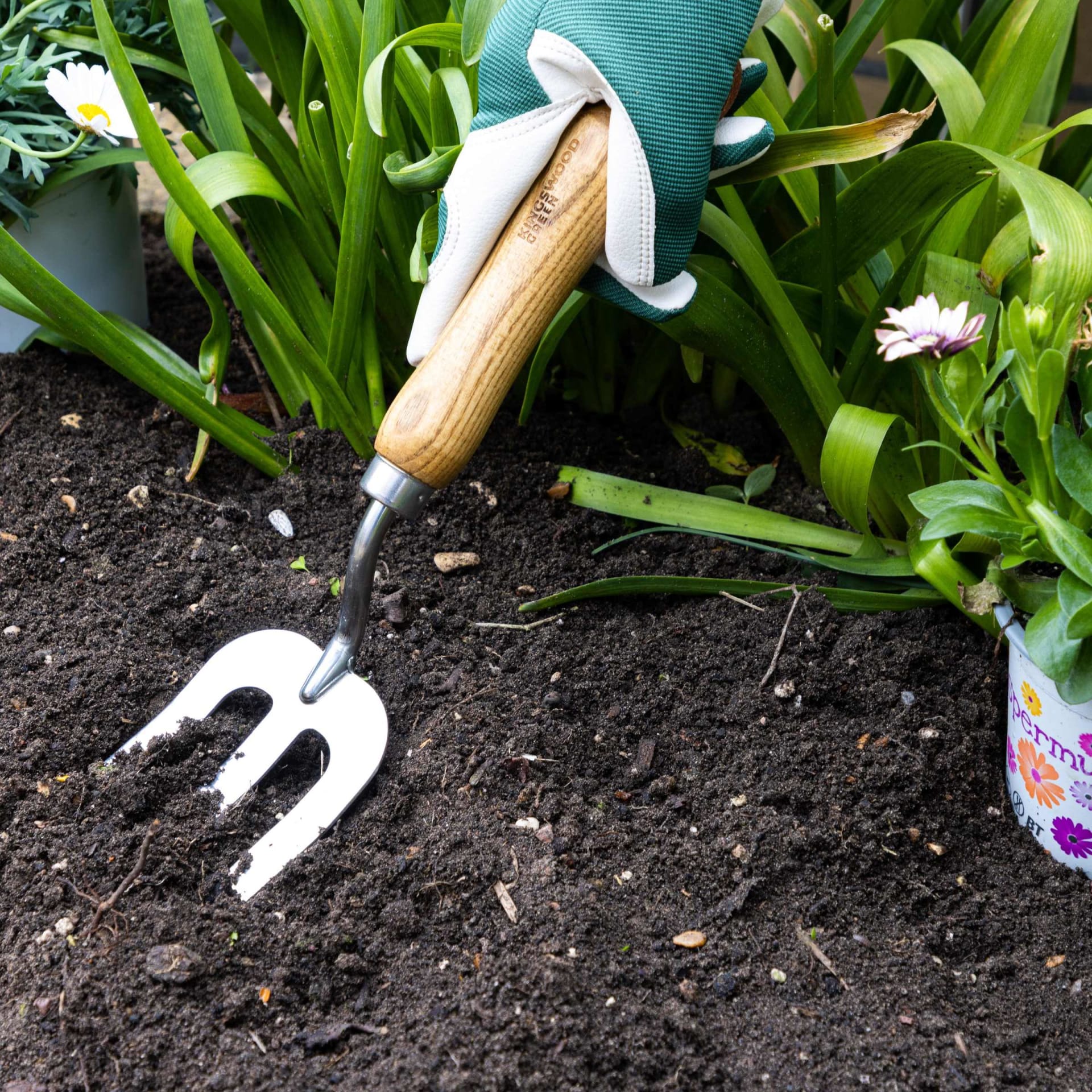 Garden hand fork wooden handle lifestyle in soil - hardware product photography UK