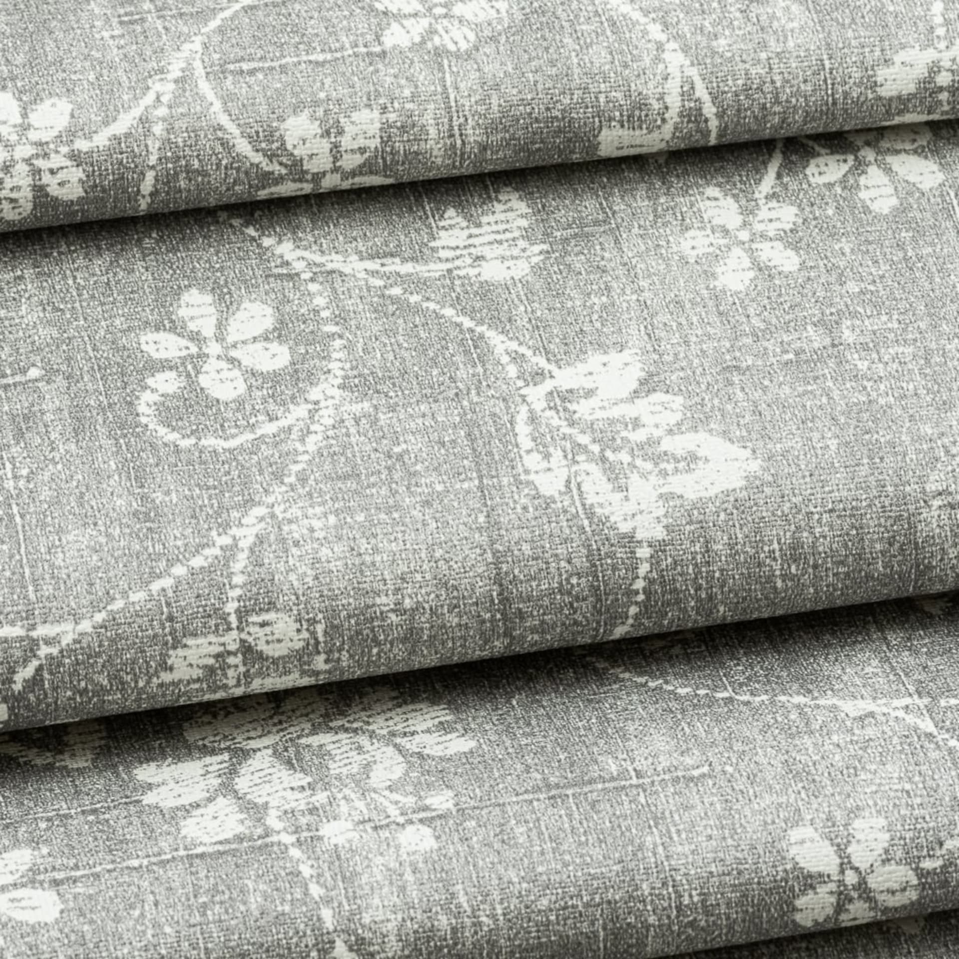 Grey floral upholstery fabric rolled in studio - fabric swatch photography UK