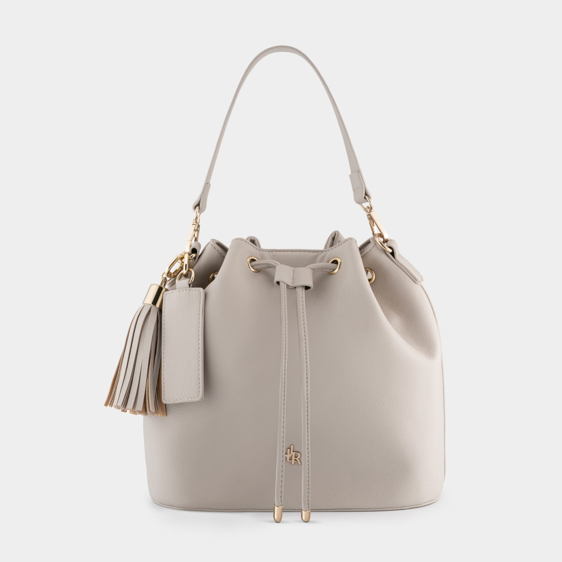 Cream leather bucket bag with tassel packshot on grey - product photography UK