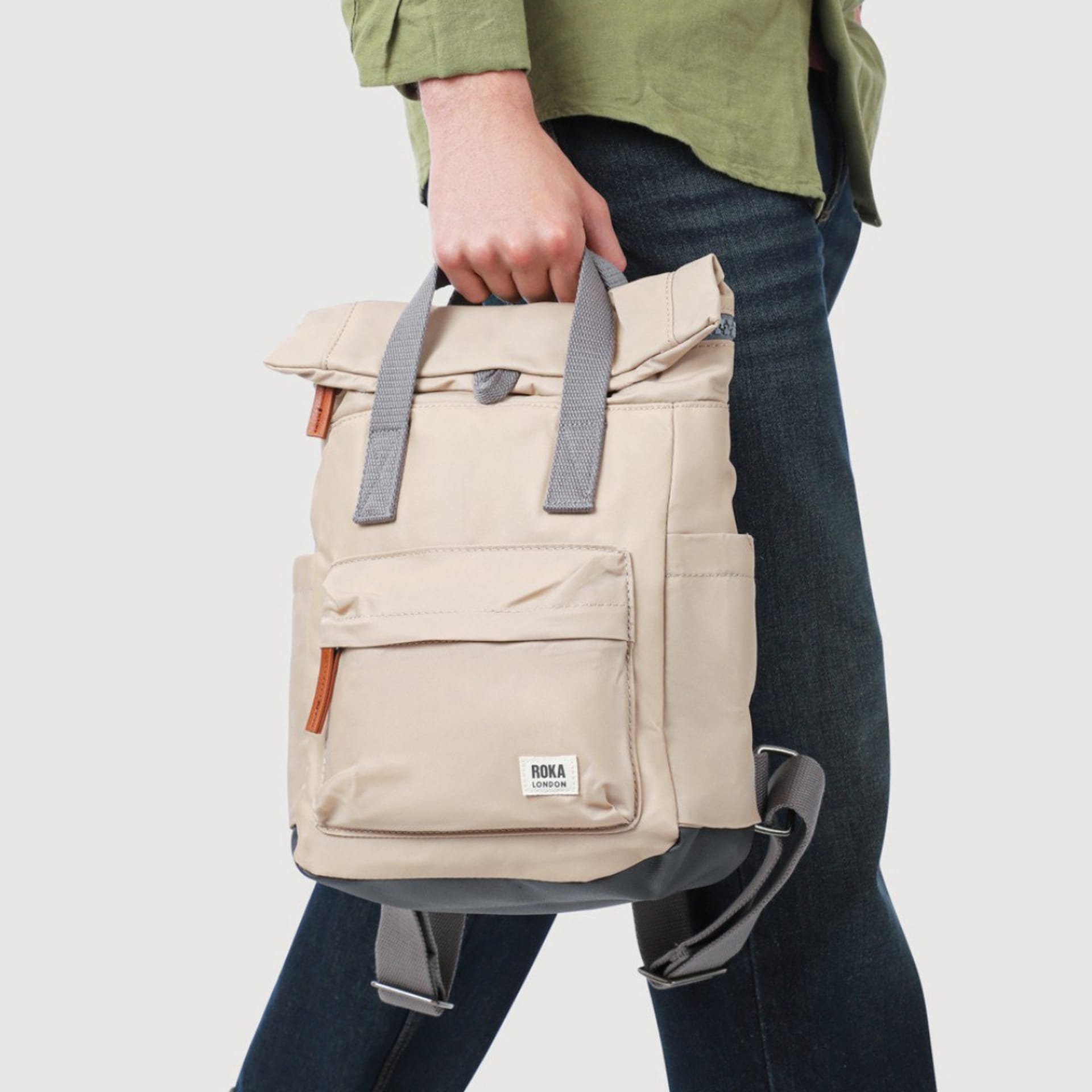 Beige Roka backpack hand held by model lifestyle - product photography UK