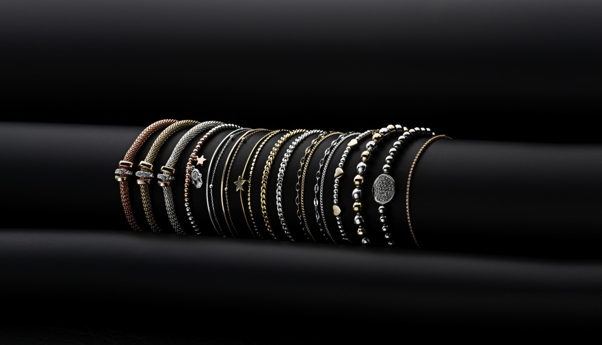 Stacked gold and silver bracelets on display - creative jewellery studio photography UK