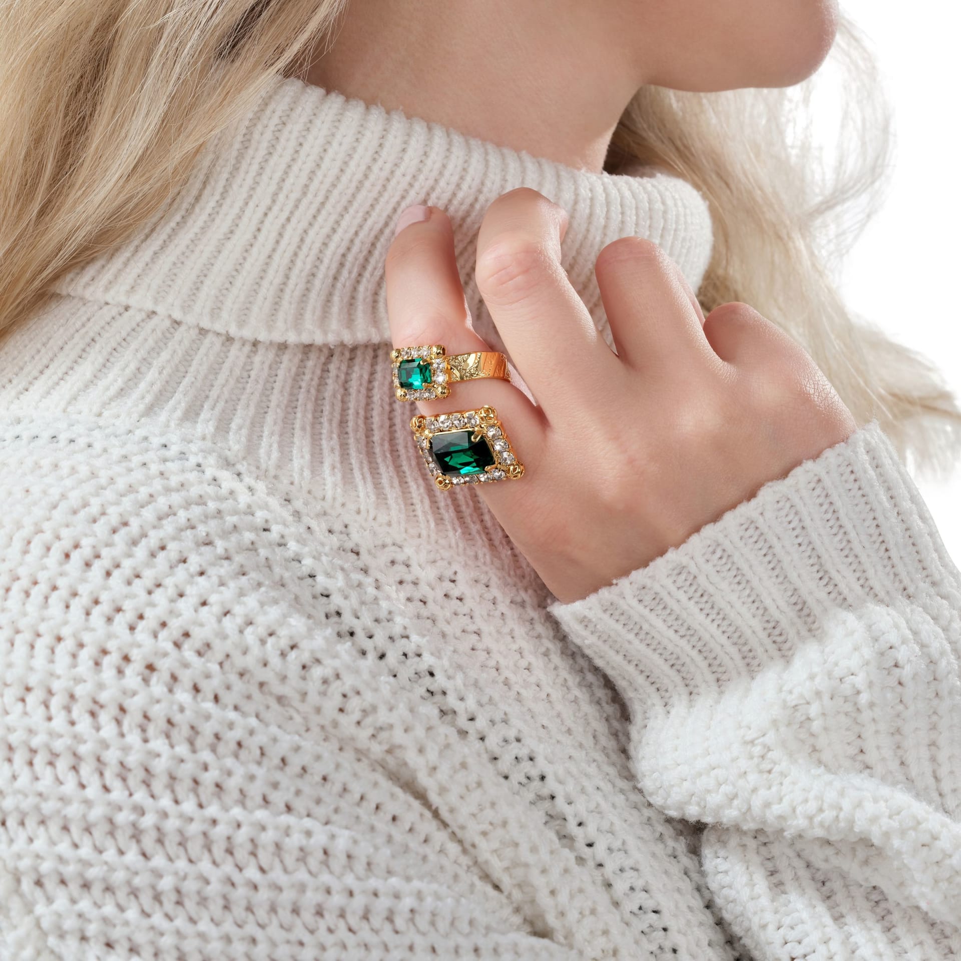 Emerald and gold rings on model hands with knitwear - styled jewellery photography UK