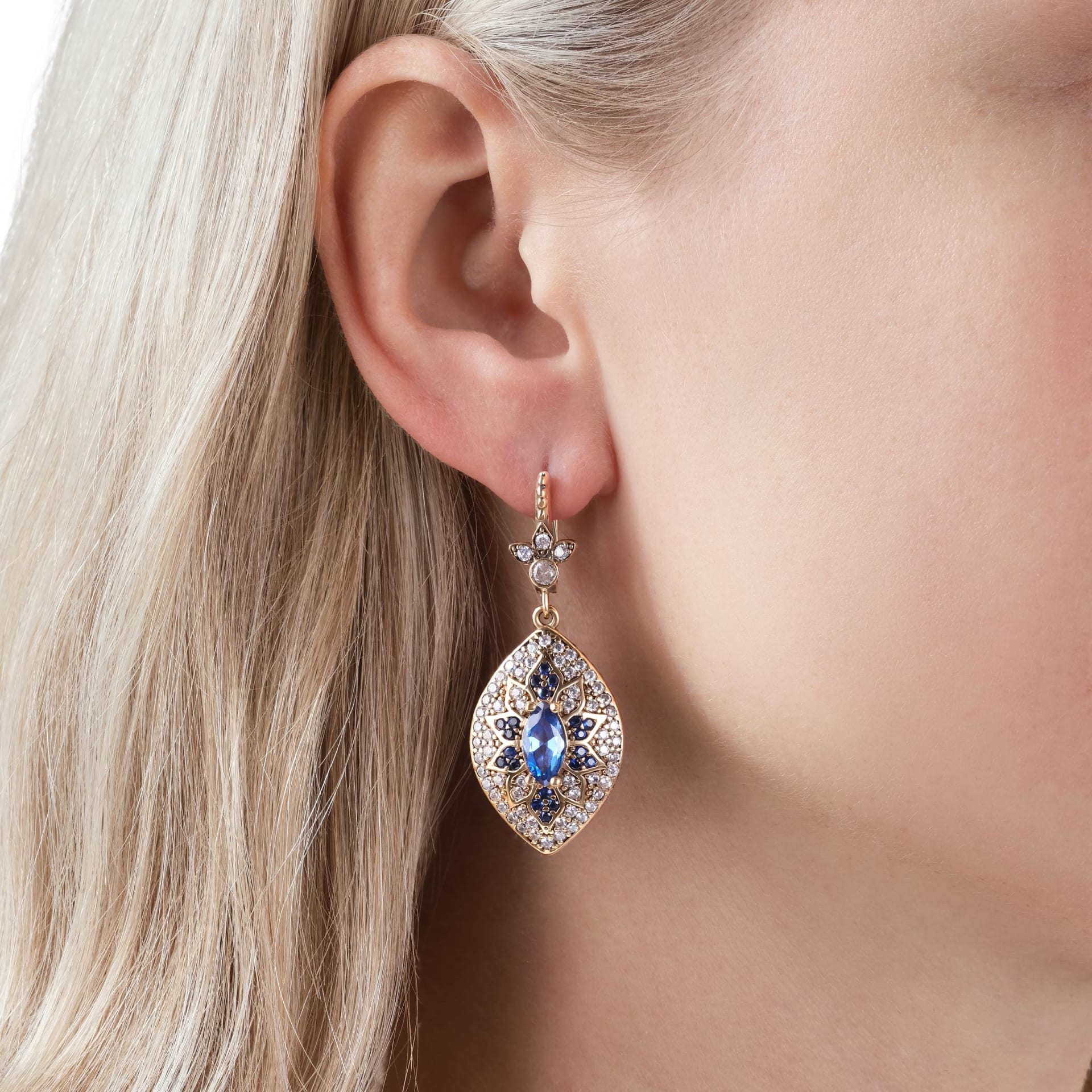 Gold sapphire drop earring close-up on model - premium jewellery lifestyle photography UK