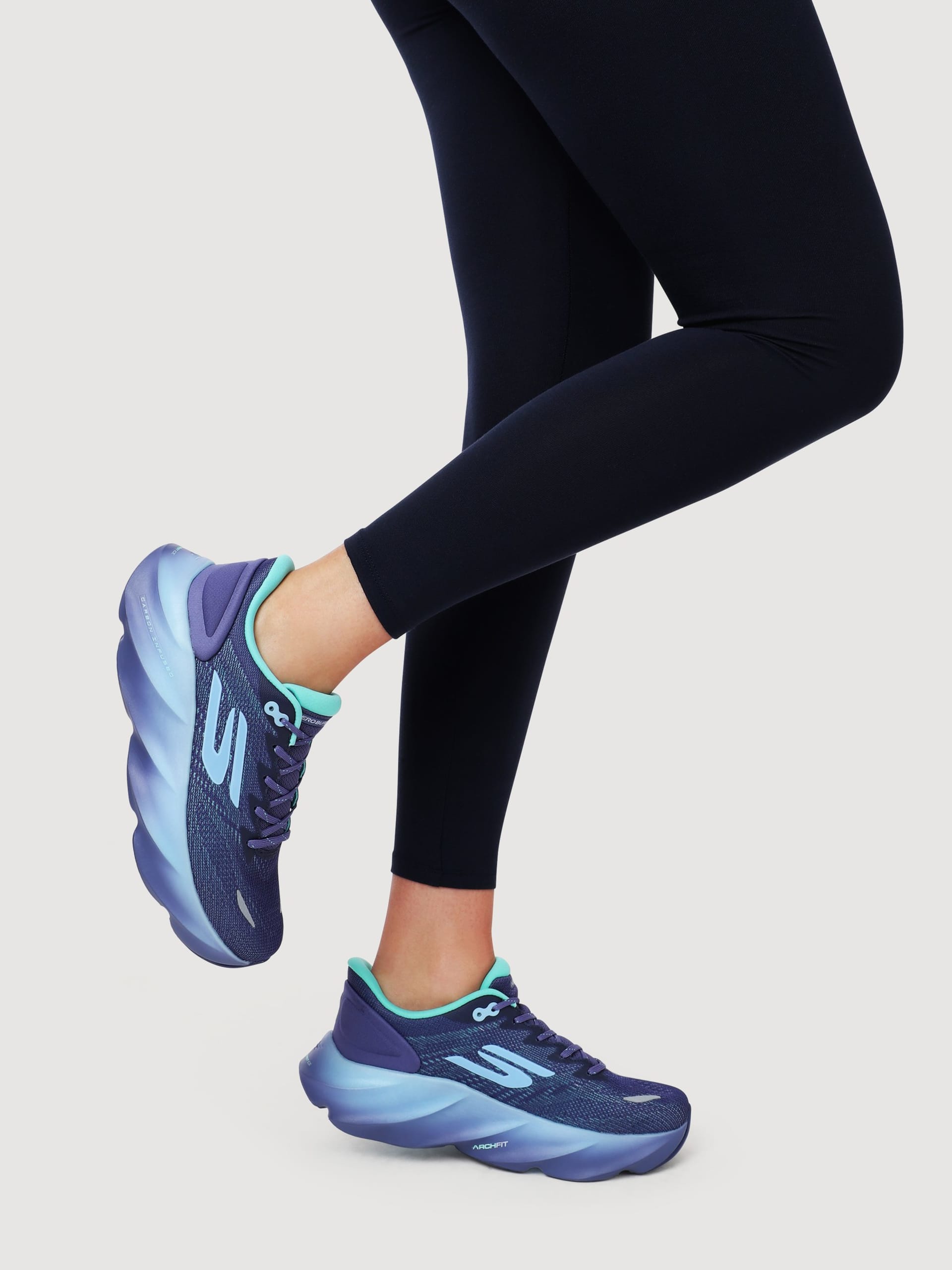 Blue running trainers on model in studio lifestyle - footwear product photography UK