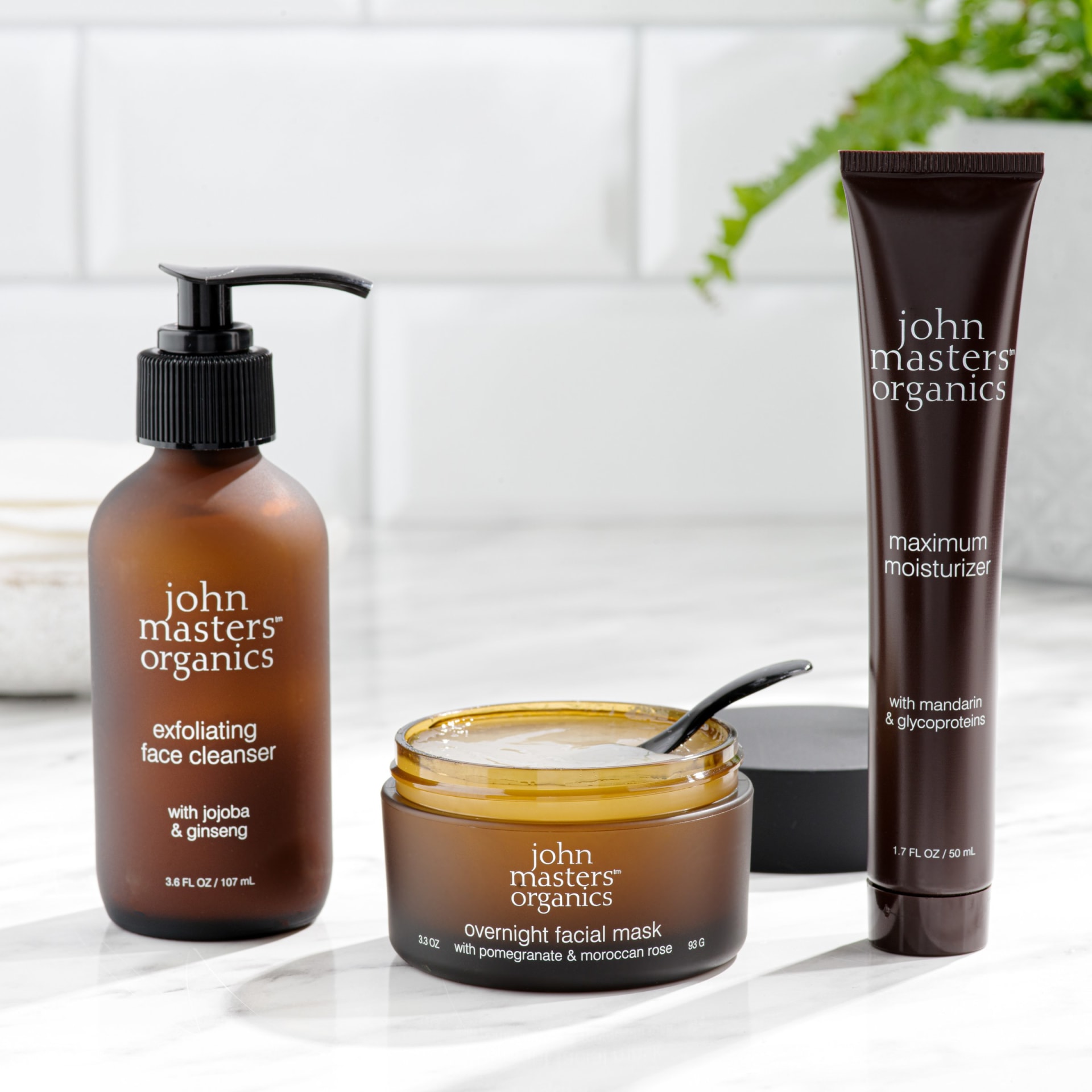Organic skincare trio lifestyle arrangement on marble surface - beauty product photography UK