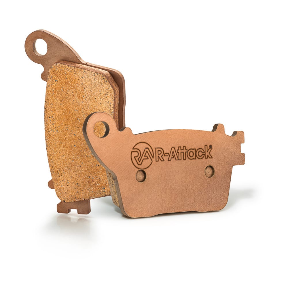 Two copper-coloured R-Attack brake pads photographed upright on white to show their shapes, friction surfaces and etched branding
