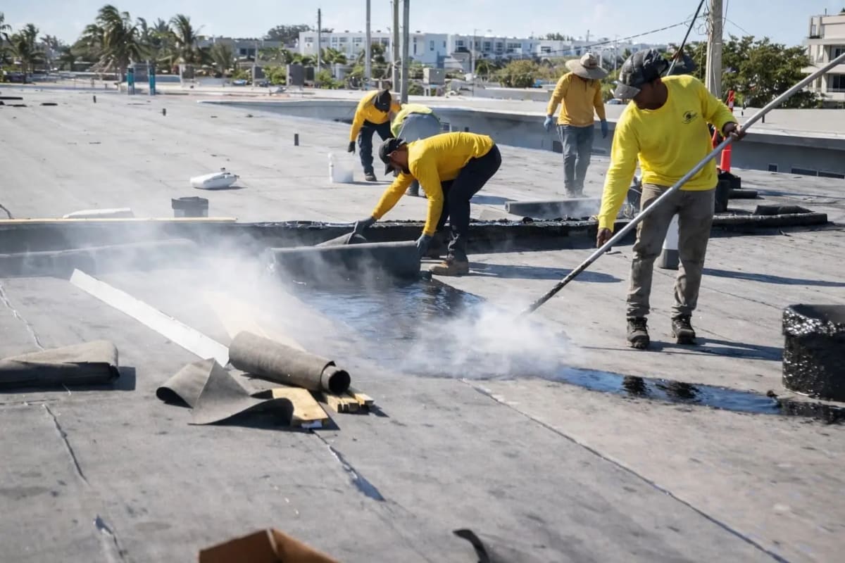 Lionz Roofing crew applying modified bitumen roofing on commercial flat roof
