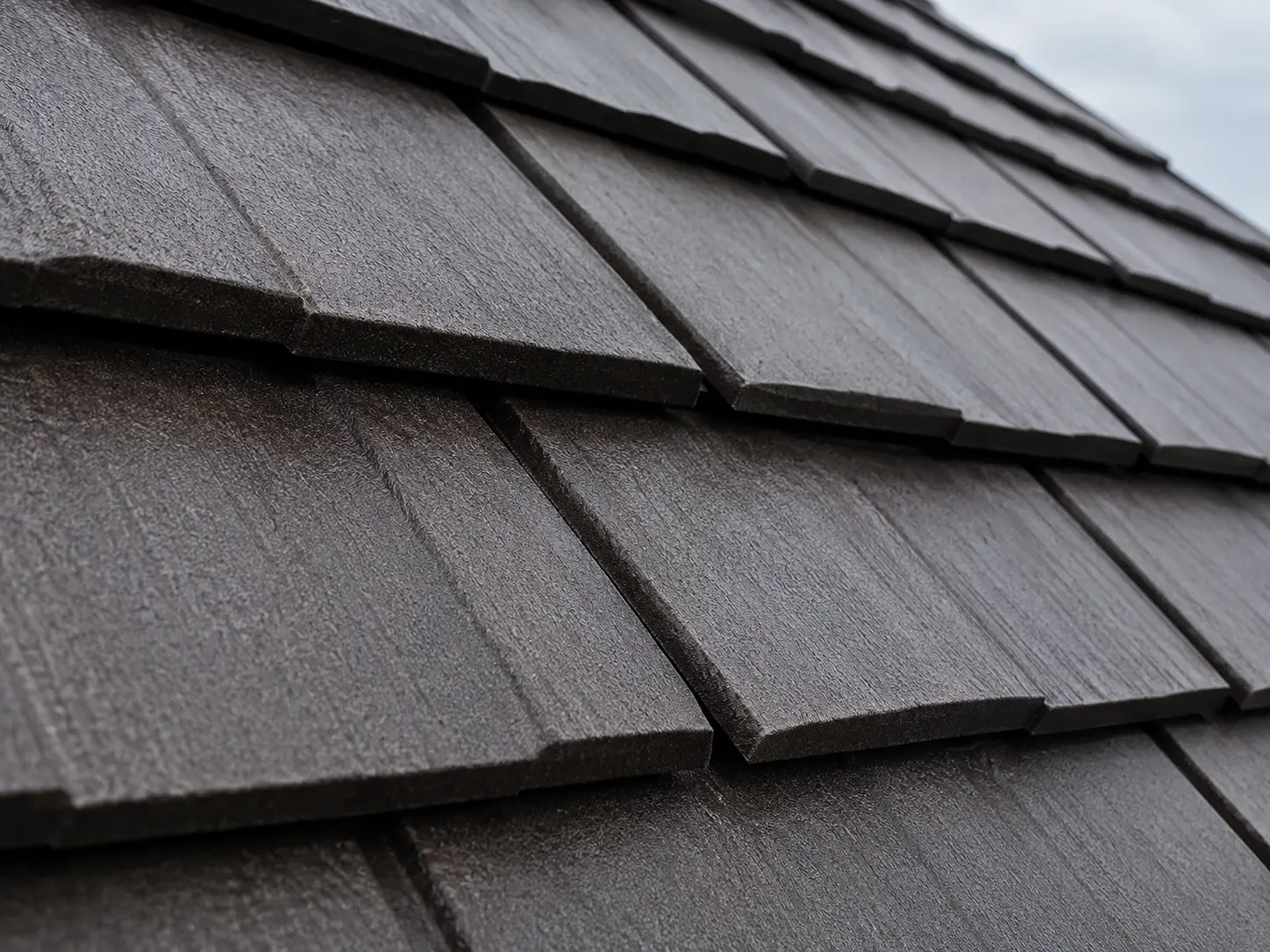 Close-up of dark metal shingle roofing panels