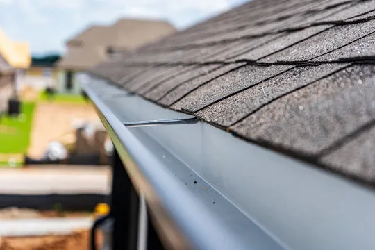 Close-up of new metal gutter and downspout materials for gutter replacement