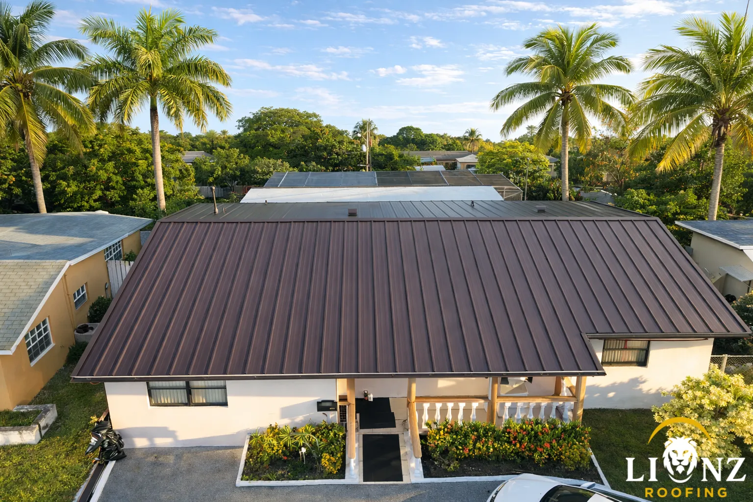 Aerial view of metal roof on South Florida home with palm trees