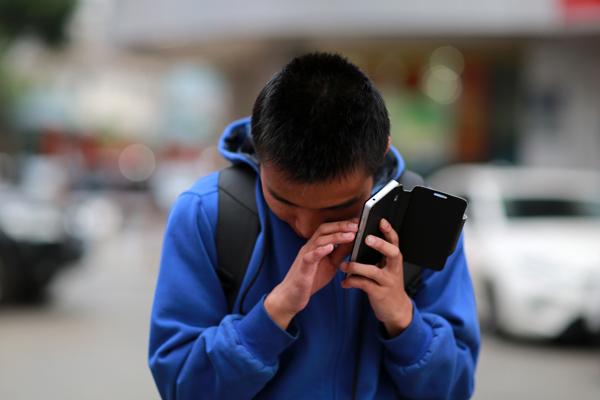 image of dissabled kid using mobile with difficulty