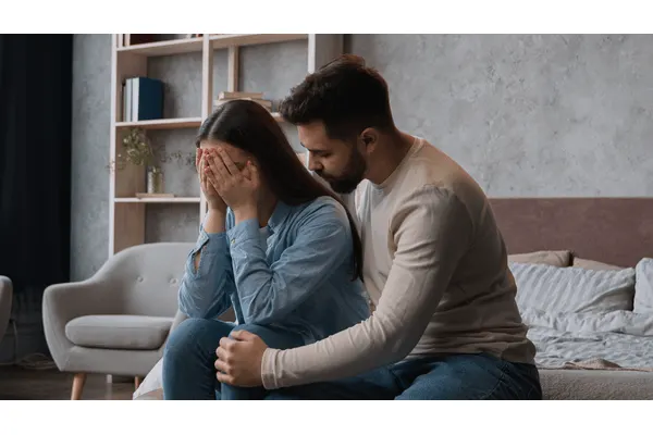 A man comforting his depressed wife.