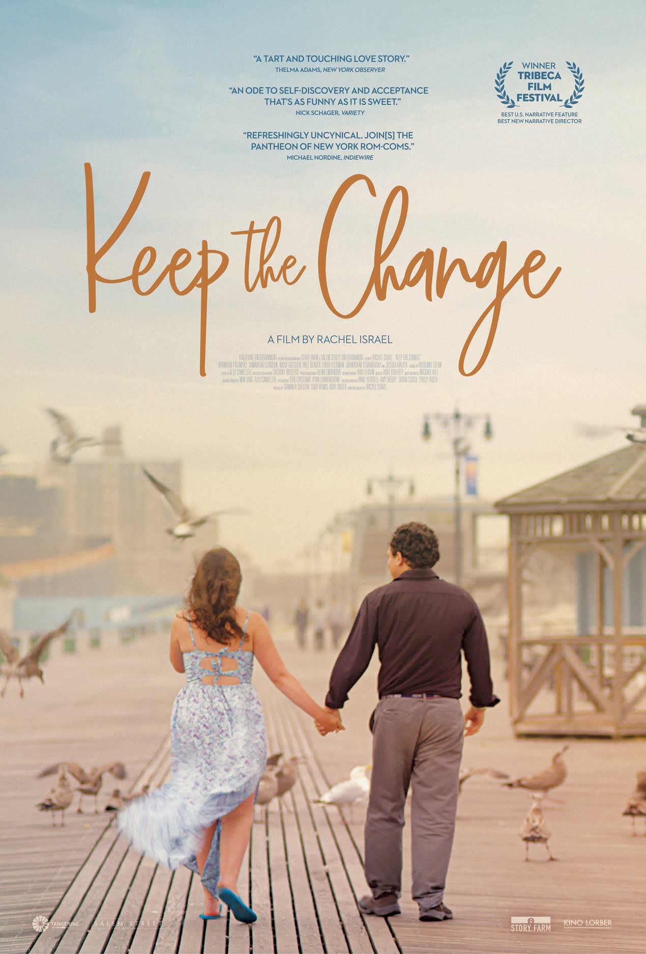 Couple holding hands on a boardwalk, surrounded by birds; a scene from the film Keep the Change by Rachel Israel.
