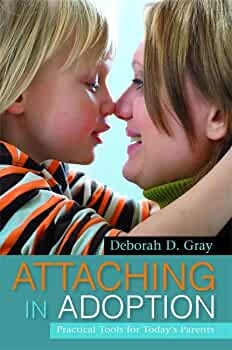 Book cover of Attaching in Adoption by Deborah D. Gray, featuring a child and parent engaging in a close interaction.