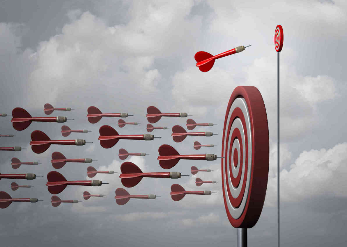 Red darts flying towards a bullseye target against a cloudy sky, symbolizing focus and goal achievement in therapy.