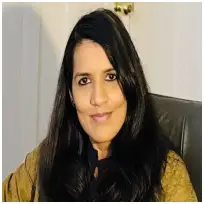 Professional counsellor with long black hair seated in an office, available for online and in-person sessions.