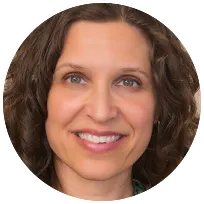 Licensed Marriage and Family Therapist with curly hair, smiling, offering compassionate support for trauma and motherhood issues.