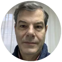 Psychologist portrait with gray hair, wearing a navy coat, reflecting over 25 years of experience in cognitive therapy.