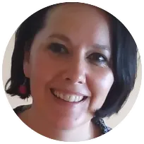 Smiling psychotherapist with short black hair, specializing in trauma-informed techniques and mindfulness-centered therapy.
