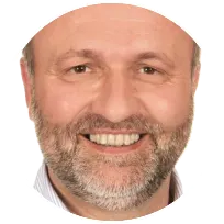 Smiling male therapist with a beard, representing a supportive environment for individual and couples counseling.