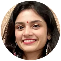 Smiling woman with long dark hair and a bindi, representing a compassionate counseling psychologist focused on positive change.
