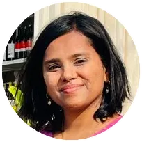 A smiling therapist with dark hair in a round frame, specializing in counseling and psychotherapy for individuals and families.