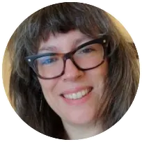 Friendly therapist with glasses smiling warmly, representing a supportive therapeutic relationship in counseling sessions.