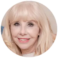 Smiling therapist with blonde hair, providing support to individuals and families in mental health and mediation.