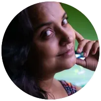 Smiling woman resting her chin on her hand, reflecting a welcoming demeanor in a psychotherapist context.